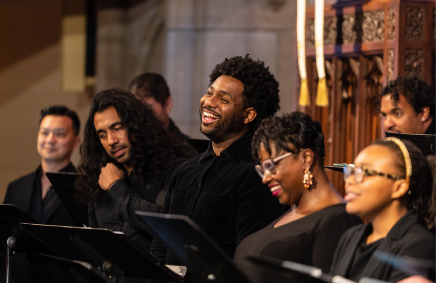 Several members of a choir singing joyously together